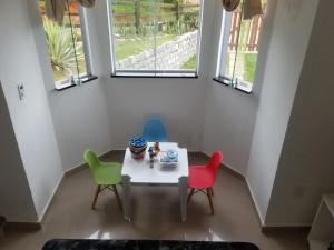 a table and chairs in a room with windows at Casa Bela Vista in Penedo +14 photos
