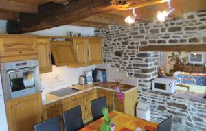 una cocina con armarios de madera y una pared de piedra. en Amazing Home In La Dore With 2 Bedrooms And Outdoor Swimming Pool, en Couesmes-en-Froulay