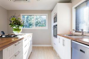 a kitchen with white cabinets and a vase of flowers at Private Cottage with Spa and Amazing Lake Views in Closeburn