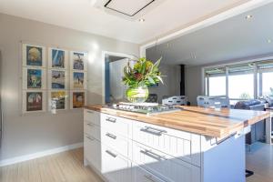 a kitchen with white cabinets and a counter top at Private Cottage with Spa and Amazing Lake Views in Closeburn