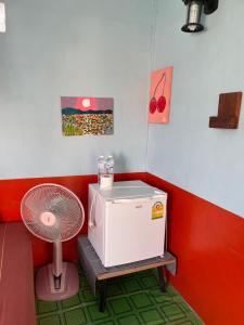 a room with a refrigerator and a fan at Pai Modern House in Pai