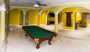 a pool table in a room with yellow walls at Villa Sweet Villa - Montego Bay in Montego Bay