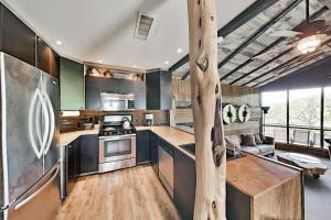 a kitchen with black cabinets and wooden floors at Lucky Goat House in Canyon Lake