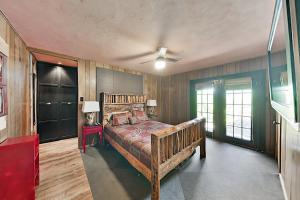a bedroom with a wooden bed and a ceiling fan at Lucky Goat House in Canyon Lake