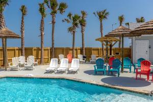 una piscina con sedie, tavoli e palme di Crab Shack a Corpus Christi