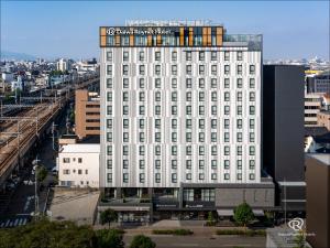 a white building with a sign on top of it at Daiwa Roynet Hotel Kanazawa Eki Nishiguchi in Kanazawa