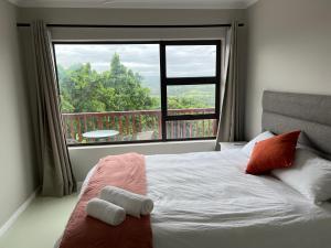 a bedroom with a bed and a large window at Fever Tree B&B in East London