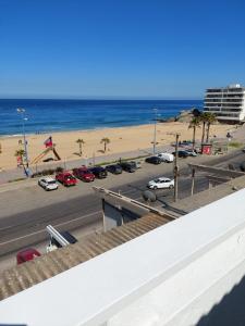 un aparcamiento junto a una playa con coches aparcados en Ocean View en Viña del Mar