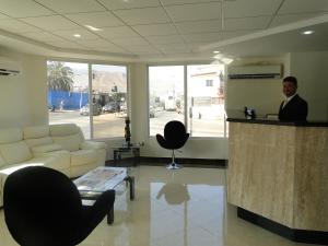 a man standing at a bar in a lobby at Hotel Costa Pacifico - Express in Antofagasta