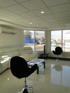 uma sala de estar com um sofá branco e duas cadeiras em Hotel Costa Pacifico - Express em Antofagasta