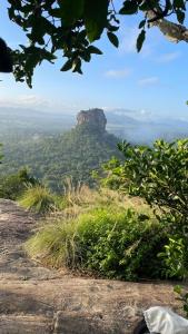 una vista sulle montagne blu dalla cima di una montagna di Sigiriya Water Guest & View Point Restaurant a Sigiriya Altre 37 foto