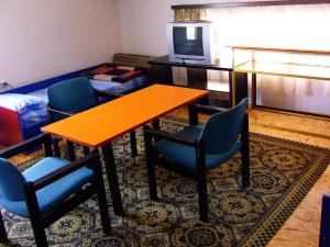 a room with a table and chairs and a tv at Hostel Domestika in Bitola