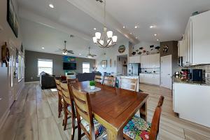 cocina y comedor con mesa de madera y sillas en Beautiful Sea en Port Aransas