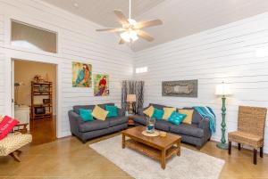 a living room with two couches and a ceiling fan at Jamaica Me Happy at Pirate's Bay Unit 303 in Port Aransas