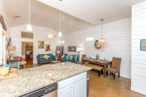 a kitchen and living room with a couch and a table at Jamaica Me Happy at Pirate's Bay Unit 303 in Port Aransas