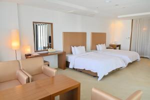 ein Hotelzimmer mit 2 Betten und einem Tisch in der Unterkunft Ecograd Hotel in Suncheon