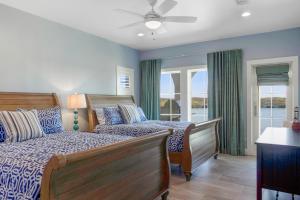 a bedroom with two beds and a ceiling fan at Big Blue at Palmilla Beach in Port Aransas