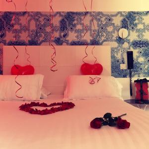 a bedroom with a bed with roses and hearts on the wall at Hotel Villa Rose in Nice