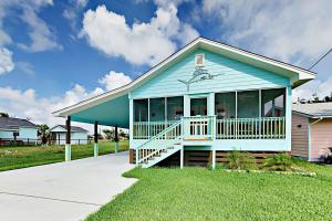 a blue house with large windows and a porch at South Pearl Sailfish in Rockport