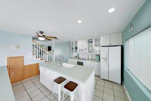 a kitchen with white cabinets and a white refrigerator at Island Escape & Huisache Townhome in South Padre Island