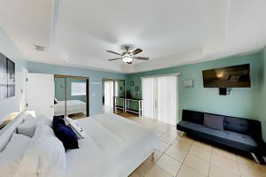 1 dormitorio con 2 camas y TV de pantalla plana en Island Escape & Huisache Townhome, en South Padre Island