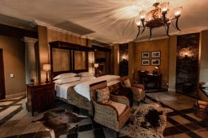 a large bedroom with a large bed and a chandelier at Dawsons Game Lodge in Badplaas