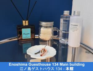 - une table en verre avec des bouteilles de savon et une brosse à dents dans l'établissement Enoshima Guest House 134, à Fujisawa