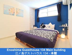 Schlafzimmer mit einem Bett mit blauer Wand in der Unterkunft Enoshima Guest House 134 in Fujisawa
