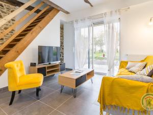 een woonkamer met een gele stoel en een tv bij Gîte Casson, 3 pièces, 4 personnes - FR-1-306-854 in Casson