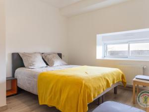 een slaapkamer met een bed met een gele deken erop bij Gîte Casson, 3 pièces, 4 personnes - FR-1-306-854 in Casson