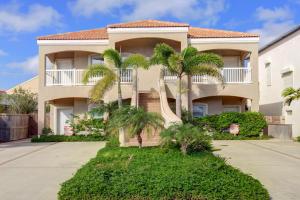 a house with palm trees in front of it at Garden Breeze Condominiums #3 in South Padre Island