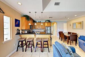 a kitchen and living room with a bar and chairs at Garden Breeze Condominiums #3 in South Padre Island