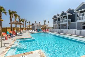a swimming pool at a villa with palm trees at Ocean Pulse in Corpus Christi