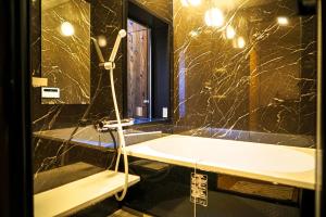 a bathroom with a tub and a sink and a mirror at INN Plus Toji Fushin in Kyoto +27 photos