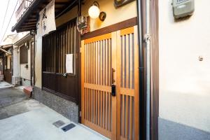 a pair of wooden doors on the side of a building at INN Plus Toji Fushin in Kyoto