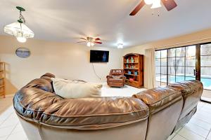 - un canapé en cuir dans le salon avec un ventilateur de plafond dans l'établissement Lantana Unit B, à South Padre Island