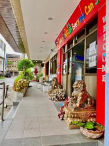 a building with statues in front of a store at Station Hotel in Trang