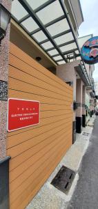 eine Holztür mit einem Schild an der Seite eines Gebäudes in der Unterkunft 煙燻貓民宿 tesla充電需電洽-無合作Ago達平台 in Taitung