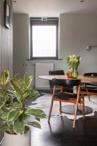 een kamer met een tafel en stoelen en een plant bij Studio Spiegelhof in Gent