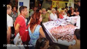 a group of people standing around a display of food at SPLENDIDE T2 NEUF COOCOONIG AVEC PETIT PATiO in Sète