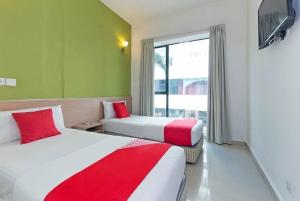 a hotel room with two beds and a window at Bintang Garden Hotel in Kuala Lumpur