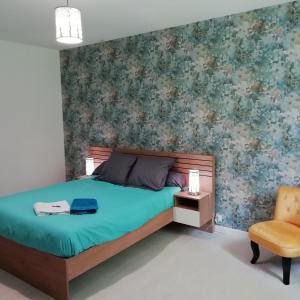 a bedroom with a bed and a chair at Au fil de l'eau à la campagne 