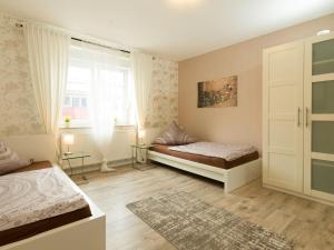 Überherrn的住宿－Ades Haus - wenn's gemütlich sein darf!，一间卧室设有两张床和窗户。