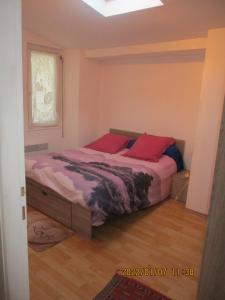 a bedroom with a bed with red pillows on it at location située à 300 mètres de la thalasso de Pornic et des plages in Pornic