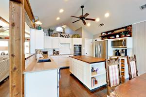 a kitchen with white cabinets and a ceiling fan at Coventry Casa in Spicewood