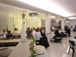 un grupo de personas sentadas en mesas en un restaurante en Hotel Riposo, en Gatteo a Mare