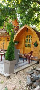 a small wooden cabin with a bench and a tree at Vila Jelena - BUNGALOV in Crni Vrh