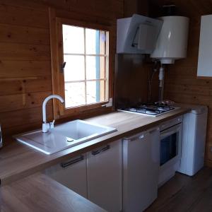 a kitchen with a sink and a stove and a window at les chalets et gite du haut taravo in Zicavo