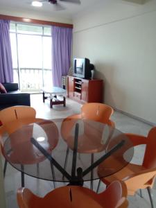 a living room with a glass table and chairs at Glory Beach Resort PriVate PentHouse in Port Dickson