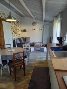 a kitchen and living room with a table and a couch at Lac Grand Lieu : maisonnette au calme avec jardin in Saint-Lumine-de-Coutais